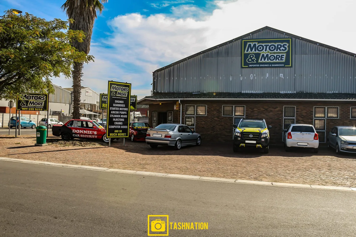 Wide angle view of the exterior and parking area at Motors & More Cape Town