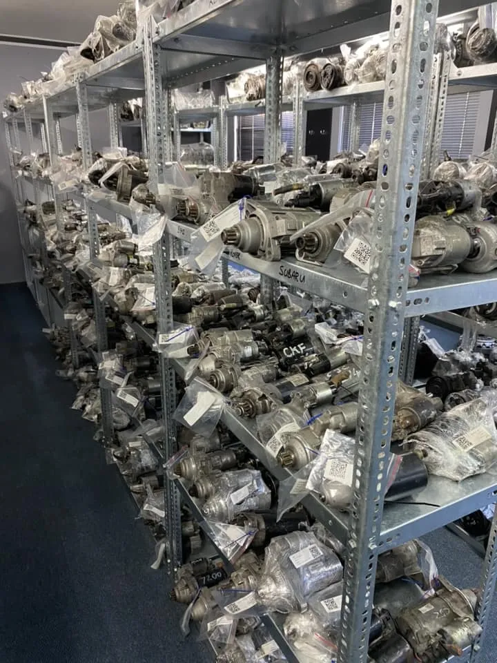 Close-up of engine parts collection on shelf inside warehouse