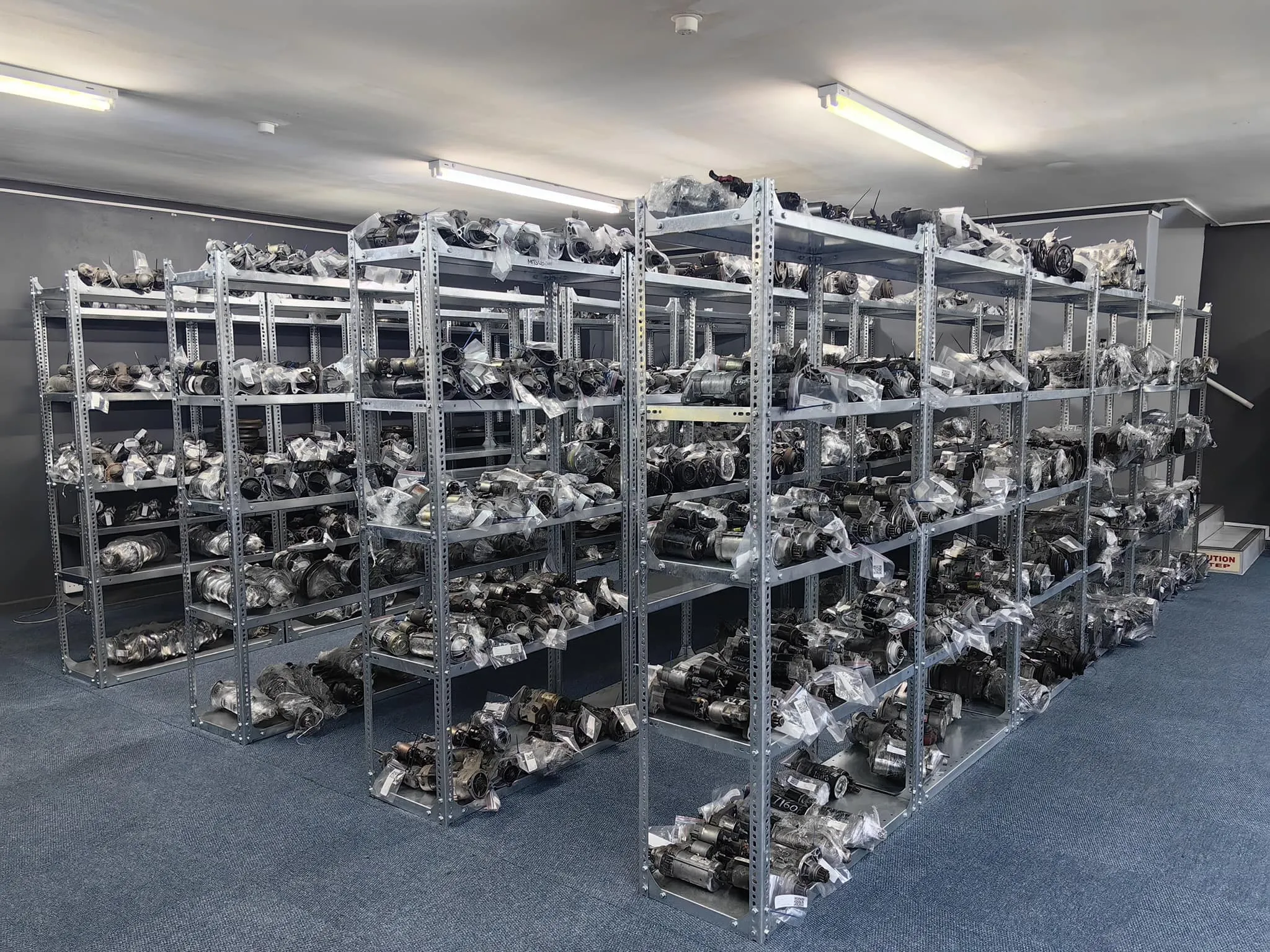 Assorted used engine parts collection inside warehouse