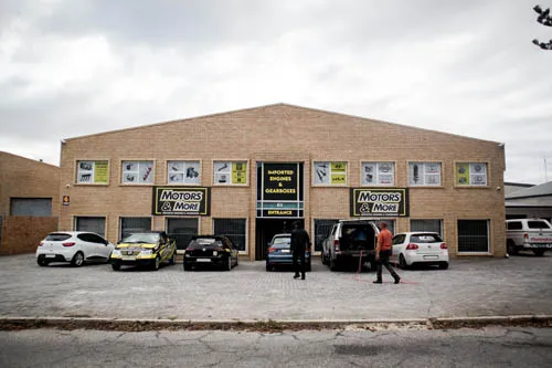 Profile view of Motors & More Gqeberha building with branded cars lined up