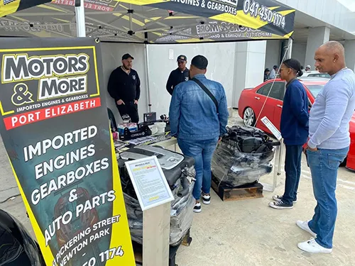 Motors & More Gqeberha branded tent at an outdoor exhibition with engine samples