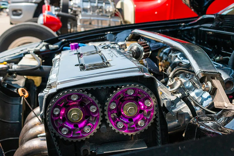 A close up of the engine of a car, showing the engine block and parts