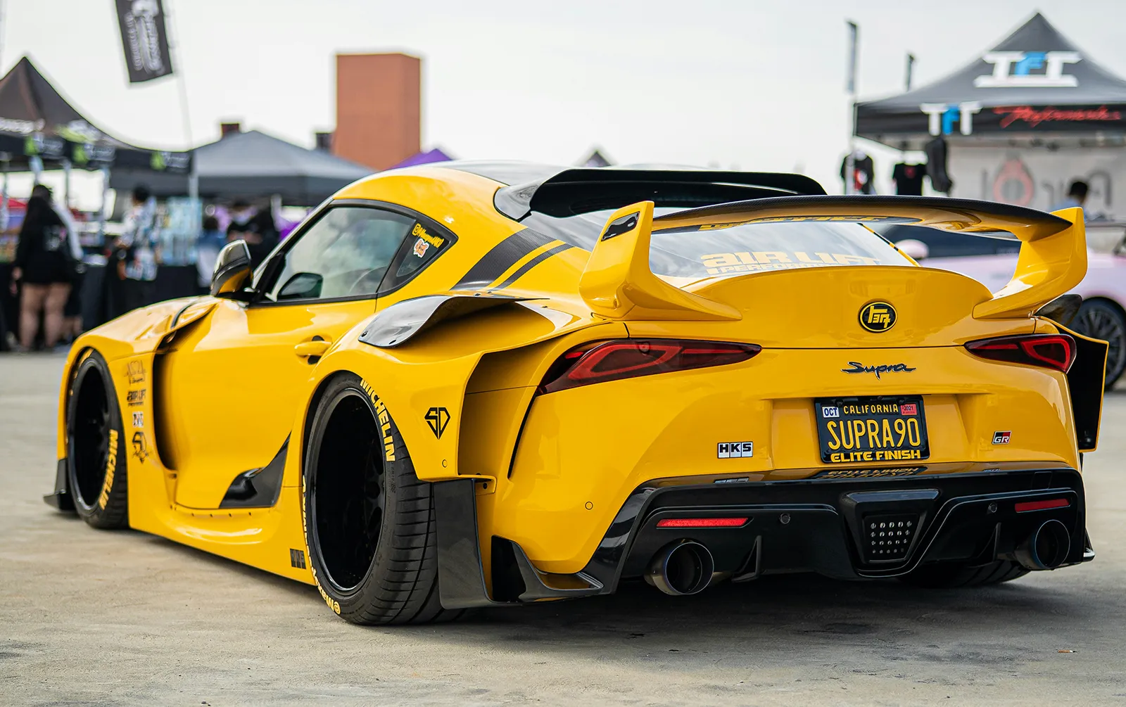 Open engine bay of a yellow car showing engine and parts